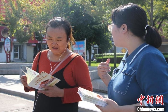 图为，东港区民族团结宣传月发放宣传材料。山东省日照市委统战部供图